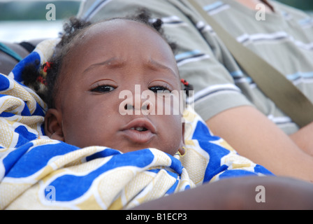 a young black girl curled up in a blanket Stock Photo