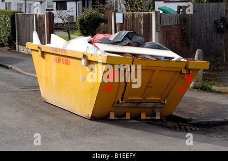 Yellow skip on the side of the road Stock Photo