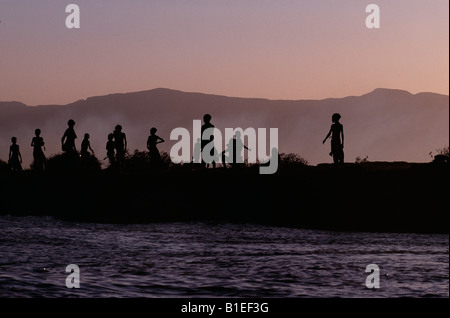 Dassanech children play on the bank of the Omo River at sunset.  Much the largest of the tribes in the Omo Valley. Stock Photo