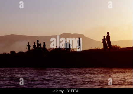 Dassanech children play on the bank of the Omo River at sunset.  Much the largest of the tribes in the Omo Valley. Stock Photo