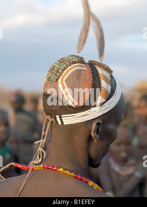 A finely decorated clay hairstyle of a young Dassanech man.The row of decorations on top of the head are ostrich feather holders Stock Photo