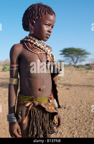 A Hamar girl in traditional attire.  Her leather skirt is made from the twisted strands of goatskin. Stock Photo
