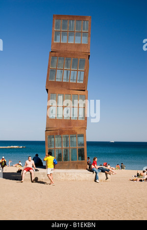 The towering rusty metal cube sculpture - known as The Wounded Star - sits alongside the maritime promenade in La Barcelonatta, Barcelona, Spain Stock Photo