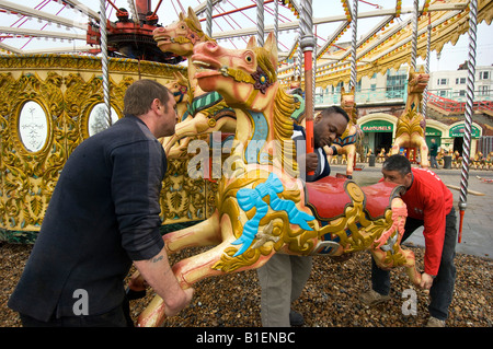 Fairground workers assembling the horses for Owen Smith and Son's Carousel on the Brighton sea front ready for the new season Stock Photo