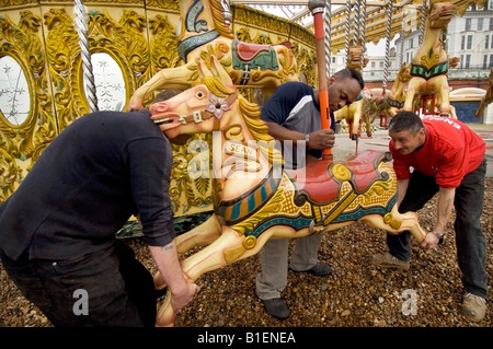 Fairground workers assemble gallopers for Owen Smith and Son's Carousel on the Brighton sea front ready for the new season Stock Photo