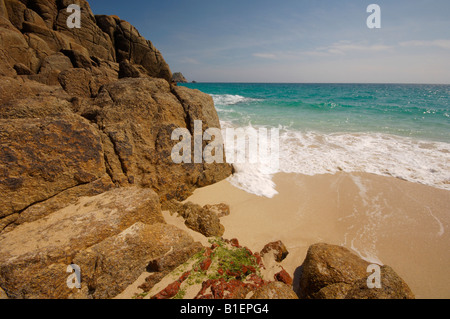 Waves rushing in over the idyllic deserted beach at Porthcurno Cornwall UK Stock Photo