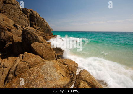 Waves rushing in over the idyllic beach at Porthcurno Cornwall UK Stock Photo
