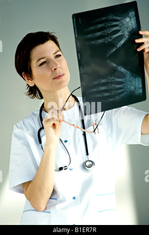 Female doctor examining an X-Ray report Stock Photo
