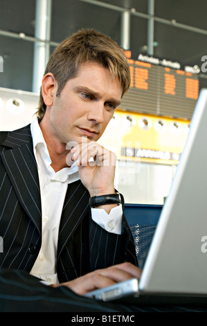 Businessman using a laptop in at an airport lounge Stock Photo