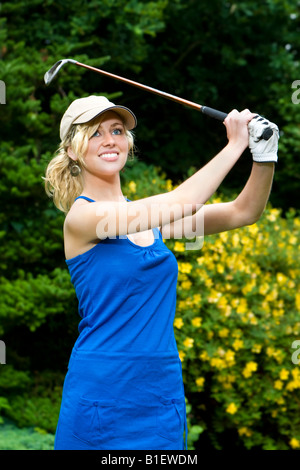 A beautiful blond haired blue eyed young woman playing golf Stock Photo