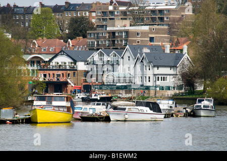 Boats moored on River Thames with houses and apartments in the background, Richmond, Surrey, England Stock Photo