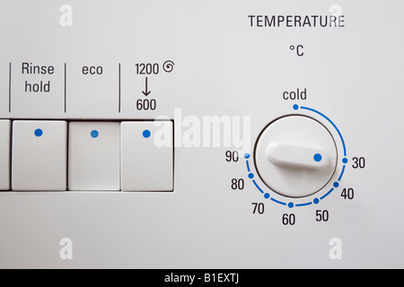 Economy half load button switch on washing machine set at low temperature of 30 degrees to save energy Stock Photo