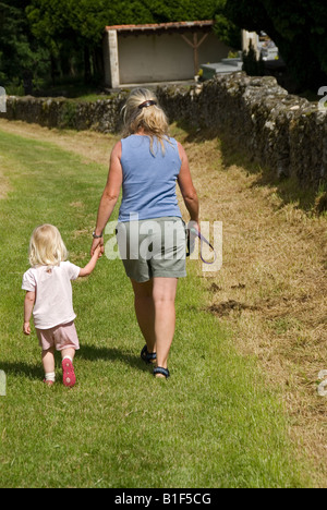 Stock photo of a mother and daughter walking along hand in hand down a country lane Stock Photo