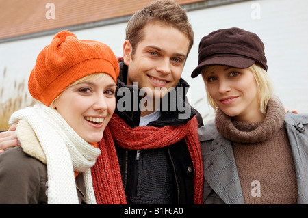 Portrait of a young man smiling with two young women Stock Photo