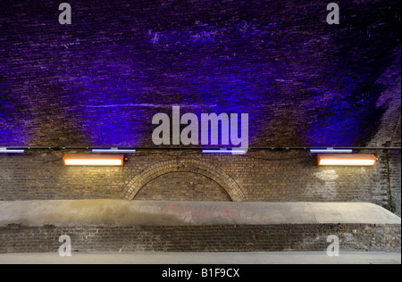 Blue light illuminates a Victorian road tunnel Southwark, London, UK Stock Photo
