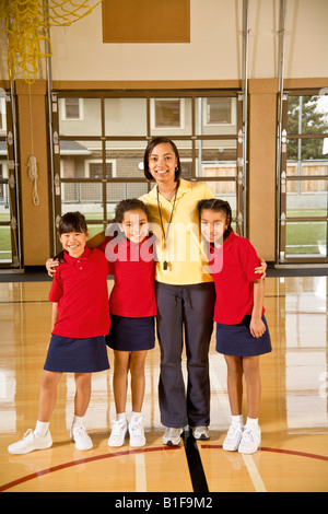 African female gym teacher with multi-ethnic students Stock Photo