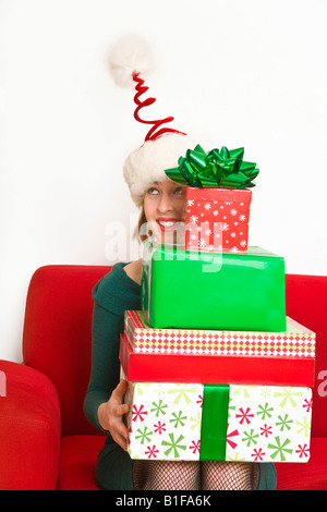 Woman holding stack of Christmas gifts Stock Photo