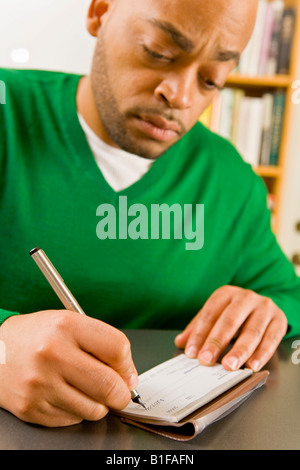 African man writing check Stock Photo