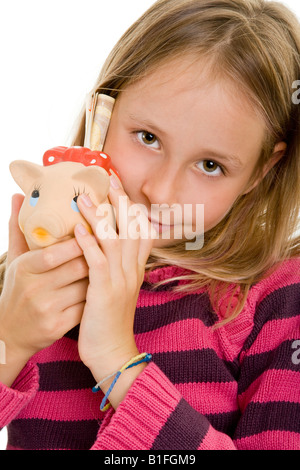 young blonde girl putting money in her piggy bank Stock Photo