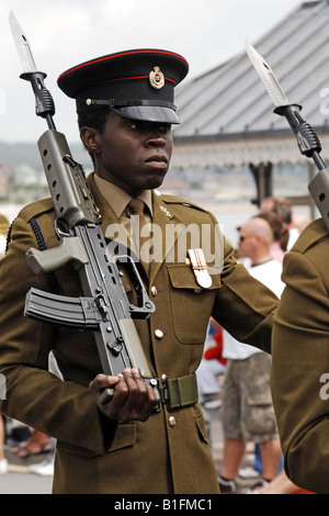 Black Soldier in the British Army marching with his Rifle in a welcome Home Parade Stock Photo