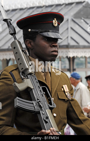 Black Soldier in the British Army marching with his Rifle in a welcome Home Parade Stock Photo