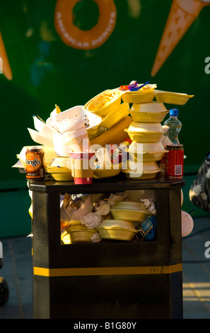 Fast food containers stacked up and overflowing on top of public rubbish bin Stock Photo