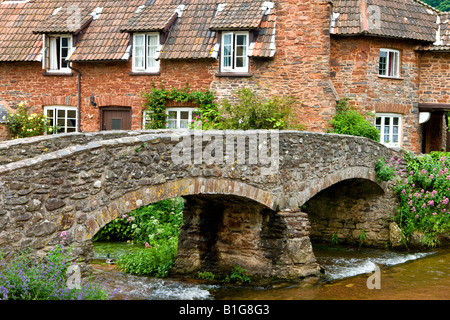 Pack horse bridge and quaint cottage in the village of Allerford Exmoor National Park Somerset England Stock Photo