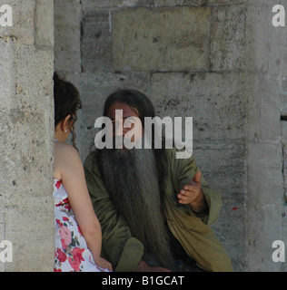 Man with long beard conversing with young lady Stock Photo