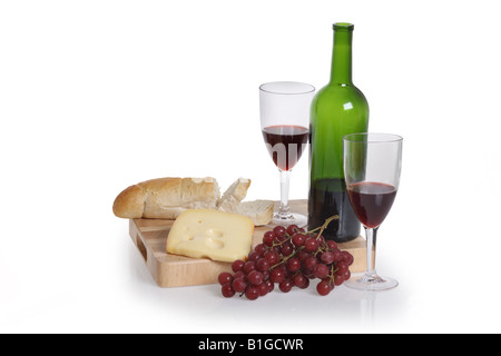 Bottle of red wine two glasses grapes cheese and bread cut out on white background Stock Photo