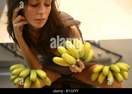 A young woman holding bananas Stock Photo