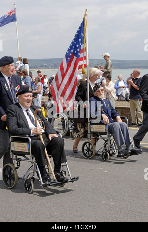 American VFW with the Stars and stripes is pushed in his wheelchair at a summer parade Stock Photo