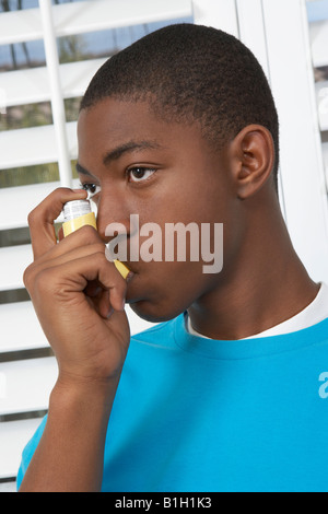 Young man using asthma inhaler Stock Photo