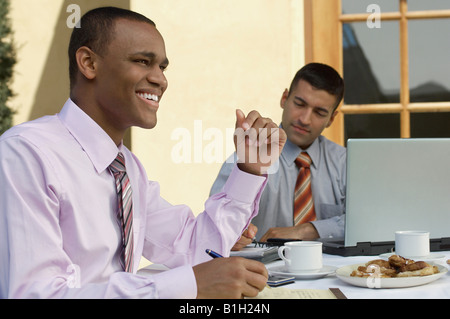Two business men working at outdoor cafe table Stock Photo