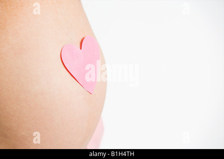 Heart on pregnant womans stomach Stock Photo