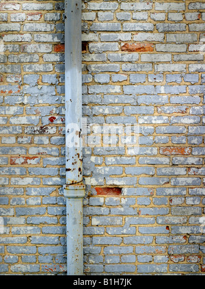 Old Brick Wall With Pipe And Peeling Paint