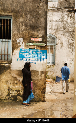 Woman and man walking in alley in Stonetown Zanzibar, East Tanzania. Stock Photo