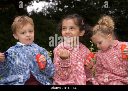 children at a private infant school playing with bubbles Stock Photo