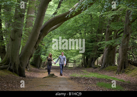 Couple walking through woods holding hands Stock Photo