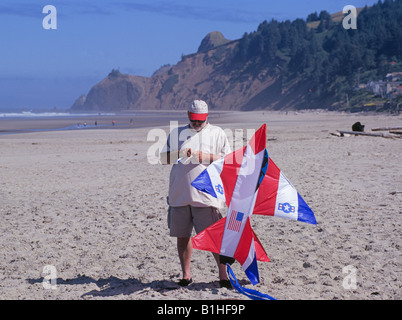 A visitor prepares to fly a large jet plane kite on the beach in north Lincoln City Stock Photo