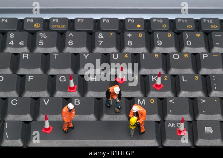 Concept shot looking down on some miniature workmen repairing a computer keyboard Stock Photo
