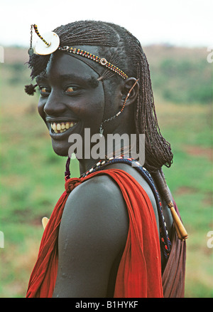 Maasai moran or warrior wears traditional beads and long hair Masai Mara National Reserve Kenya East Africa Stock Photo