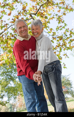 Senior couple dancing near a tree
