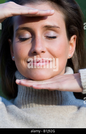 young woman wearing a turtleneck, smiling, closed eyes Stock Photo
