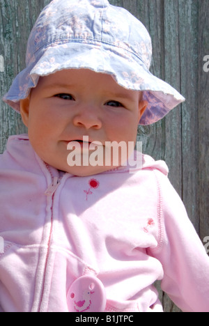 Beautful baby girl in pink outfit and sun cap Stock Photo
