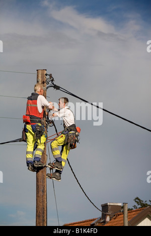Two electricians repair the lines on Power Pole after a storm in an outskirt of Gothenburg Sweden Jun 2008 Stock Photo