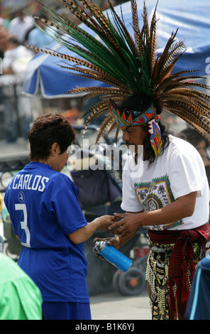 Aztec Purification Ritual Shaman with feathered headdress performing a traditional limpia on a ...