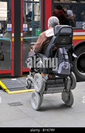Disabled person operating a gyroscope balanced iBOT Mobility System powered wheelchair boarding a bus using a drive on ramp Stock Photo