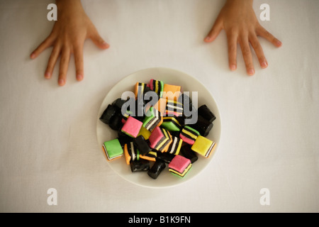 Hands of child six year old boy waiting for permission to take a candy Stock Photo