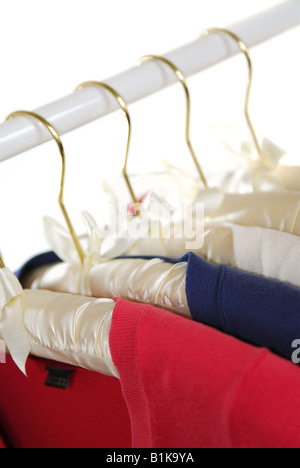 Colorful women's sweaters on a rack on padded hangers Stock Photo