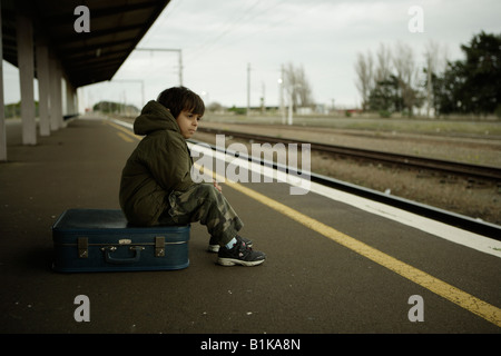 Boy aged six waits for train on platform at railway station Palmerston North New Zealand Stock Photo
